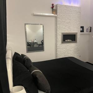 a bedroom with a black bed and a mirror at Palese Profumo di Mare in Santo Spirito