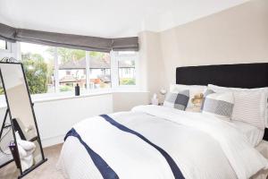 a white bedroom with a large bed and a window at Pass the Keys Stunning home near Didsbury Village - Sleeps 6 in Manchester