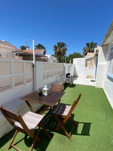 patio con mesa de madera y sillas en el balcón en PETRA, en Denia