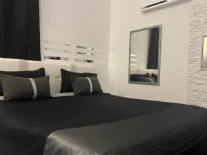 a bedroom with a large black bed with a mirror at Palese Profumo di Mare in Santo Spirito