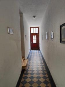 um corredor com uma porta vermelha e um piso xadrez em 3 min walk to Bahnhof -Peaceful room with Balcony em Mannheim