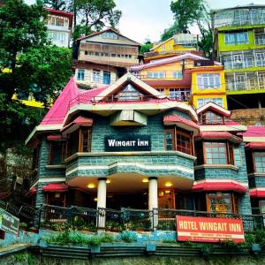 un edificio con una señal delante de él en Wingait Inn - Hotel Near The Mall Road, en Shimla