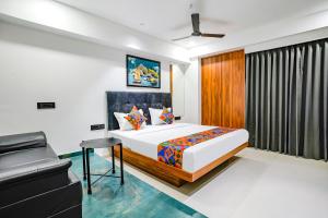 een slaapkamer met een bed en een bank erin bij FabHotel Royal King I in Surat