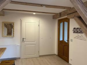 a room with a white door and wooden ceilings at Rustica im alten Speicher in Schönberg