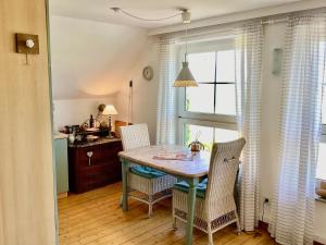 a dining room with a table and two chairs at Landhaus am Deich in Dornum +34 photos
