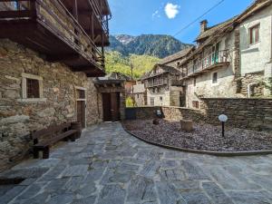 a stone alley with a bench in a village at Dimora Storica Casa Vanni in Villadossola