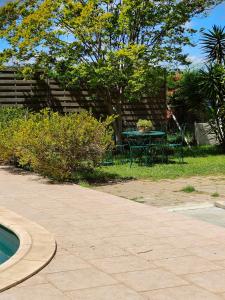 a patio with a table and chairs in a yard at Maison de campagne piscine et jardin privatifs près de la plage in Aléria