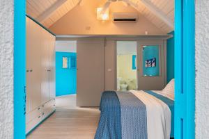 a bedroom with a bed and a bathroom at Resort Baia del Silenzio in Pisciotta