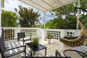 a patio with chairs and a hammock on a white fence at Semiramis Guesthouse in Adamantas