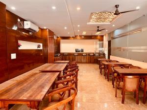 een eetkamer met houten tafels en stoelen bij Spring Sky - A Four Star Luxury Hotel in Rishīkesh