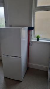 a white refrigerator in a room with a window at Fair Oak Self-Catering Accomodation in Sandown