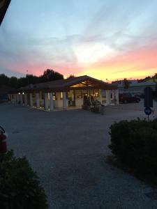 a building with a parking lot with a sunset in the background at Camping Venezia Village in Mestre