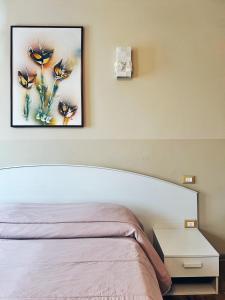 een slaapkamer met een bed en een schilderij aan de muur bij Locanda Munerato in Padua