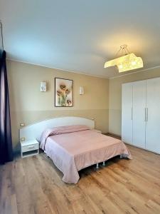 um quarto com uma cama com uma colcha rosa em Locanda Munerato em Pádua