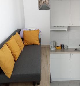 een bank met gele kussens in een keuken bij Miko apartamentai in Kaunas