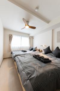 1 cama grande en un dormitorio con ventilador de techo en Plumeria en Naebochō