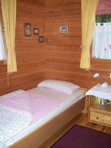 um quarto com uma cama num quarto de madeira em Komfortables-Ferienblockhaus-Nr-27-56-qm-bis-4-Personen-Viechtach-Jaegerpark em Viechtach