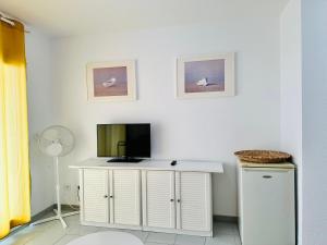 Habitación con escritorio blanco y TV. en Roc Mar 2 5C - Apartamento cerca del centro y de la playa - terraza con vistas al mar y al puerto, en Roses