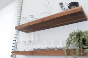 a row of glasses on a wooden shelf at PORT CITY HAIFA - Luxury Seaview Penthouse w Jaccuzzi in Haifa