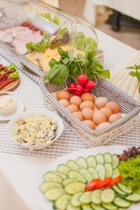 a table with eggs and vegetables and other foods at Hotel Villa Eva in Gdańsk