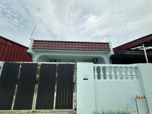 una casa blanca con una puerta y una valla en Home In Johor Bahru Near Sutera Mall, en Skudai