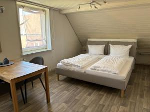 Haus Hohensee في كلاوستال-زيلرفيلد: سرير في غرفة مع طاولة ونافذة