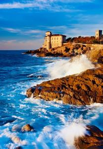 a castle on the rocks near the ocean at JCK Tuscany Apartment in Livorno