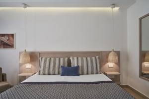a bedroom with a large bed with a blue pillow at Atlantica Aeneas Resort in Ayia Napa