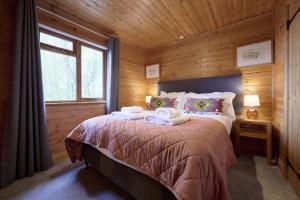 ein Schlafzimmer mit einem Bett mit Handtüchern darauf in der Unterkunft Dunnock Lodge with Hot-tub in Carlisle
