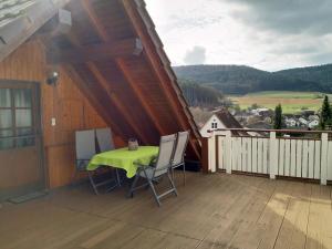 a patio with a table and chairs on a balcony at Ferienwohnung Morretalblick in Buchen