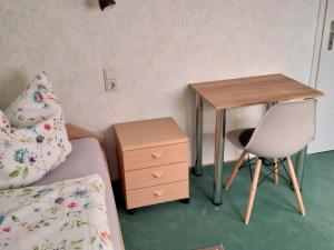 a bedroom with a desk and a bed and a chair at Ferienwohnung Morretalblick in Buchen