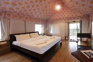 a bedroom with a large bed with an orange patterned ceiling at Hostel Desert camp Sam in Jaisalmer