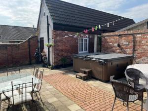 a patio with a hot tub and a table and chairs at The Little Hexthorpe house in Doncaster