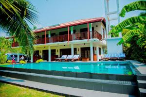 una casa con piscina frente a ella en Lagoon Bentota Resort, en Bentota