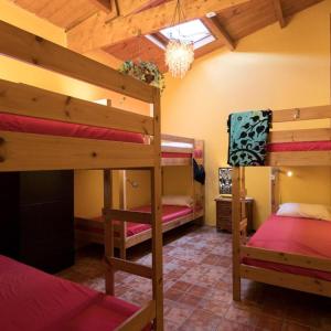 a room with three bunk beds and a chandelier at Los Amigos NEST hostel in La Mareta