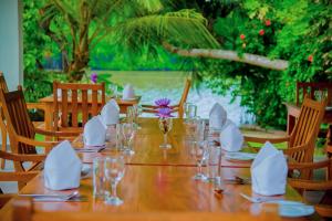 Lagoon Bentota Resort في بينتوتا: طاولة خشبية عليها كاسات ومناديل