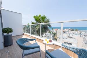 a balcony with chairs and a table and the ocean at PORT CITY HAIFA - Luxury Seaview Penthouse w Jaccuzzi in Haifa