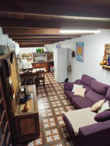 Il comprend un salon avec un canapé violet et une cuisine. dans l'établissement La cuadra de Juan, à Icod de los Vinos