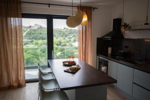 une cuisine avec une table et des chaises ainsi qu'une grande fenêtre dans l'établissement Four M, à Cavtat