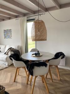 a dining room with a table and four chairs at Guesthouse The White House - gehele huisje in Klaaswaal