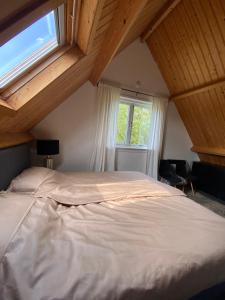 a bedroom with a large white bed with a window at Guesthouse The White House in Klaaswaal