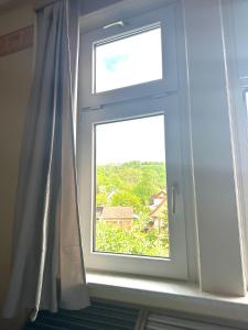 ventana en una habitación con cortina en Kimbab Restaurant und Pension, en Ruhla
