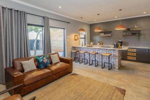 a living room with a couch and a kitchen at Amara Cottage in Otjiwarongo