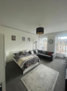 una camera con letto e divano di Spacious 3-bed Flat with Castle Views a Edimburgo