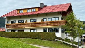 ein großes Haus mit rotem Dach in der Unterkunft Alpen Lodge Riezlern in Riezlern