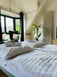 1 cama blanca grande en una habitación con ventanas en AMAO-Green I 90qm I Zentrum I Maisonette I Dachterrasse I King-Size Boxspringbetten I EuropaPark, en Lahr
