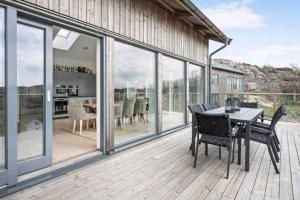 a patio with a table and chairs on a deck at Villa Blomberg in Bovallstrand