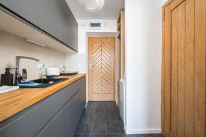 a kitchen with a counter and a wooden door at Wspólna City View Studio in Warsaw