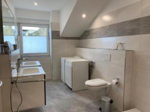 ein Badezimmer mit Toilette und Waschbecken und einem Fenster in der Unterkunft Amselstern Binz in Binz