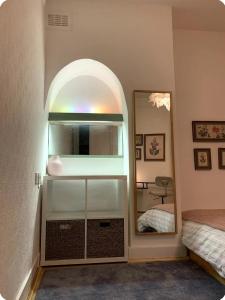 una camera da letto con uno specchio ad arco e un letto di Kenwood Gem a Edmonton